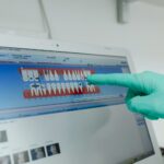 Dentist demonstrates dental software on monitor pointing with gloved hand